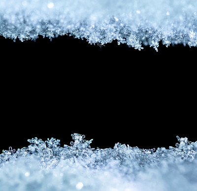 雪花特写的自然雪纹理，孤立在黑色背景上，中间有文本空间。节日礼品卡模板。雪的宏观纹理。