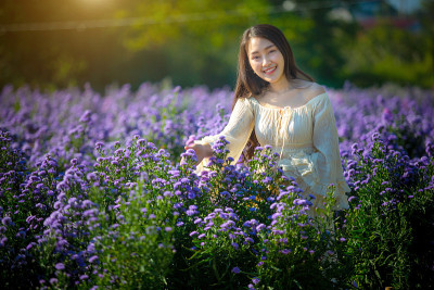 美丽的亚洲女孩在花农场拍照。愉快地在泰国清迈