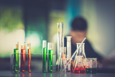 化学实验室桌上的玻璃器皿和教室里模糊的学生