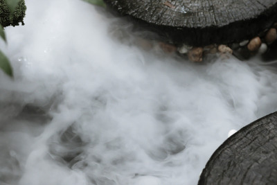 背景的散焦和模糊图像。白色蒸汽，温泉，间歇泉喷口的沸腾和蒸腾水，大石块排列，沸水飞溅。特写镜头,复古