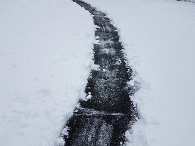 铺着柏油的车道在冬天铲着雪白的雪