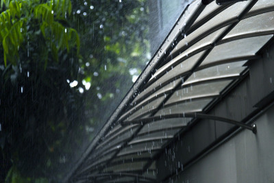 特写雨滴/水滴与水一起落在城市街道的地板上