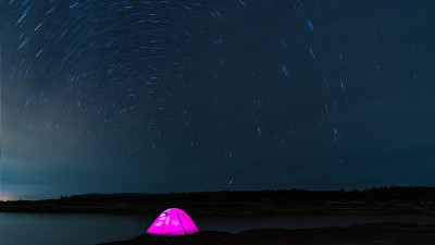 美丽的夜景彩色的星星划过天空。夜间延时摄影。