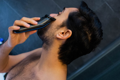 男人用剃须刀刮胡子