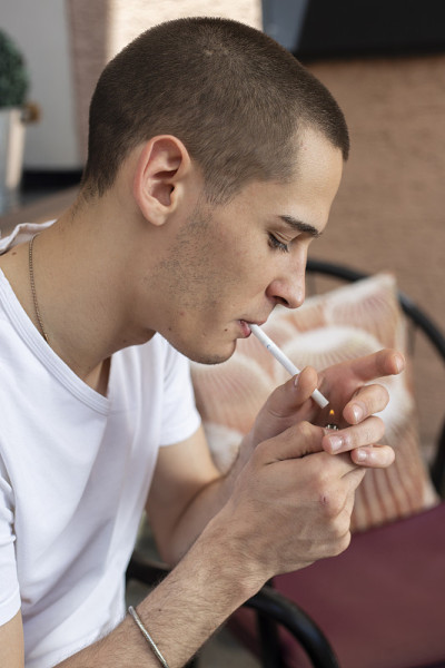 年轻男子点燃香烟的肖像