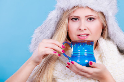 金发女人在冬天毛茸茸的帽子喝