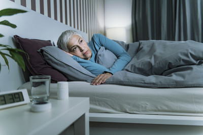 失眠——睡眠障碍。担心的老年妇女遭受失眠，躺在床上，熬夜