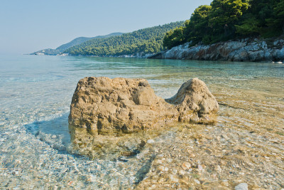早晨，在斯科佩洛斯岛米利亚海滩，海面上的岩石平静而清澈的绿松石水