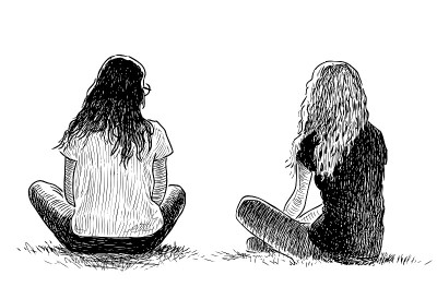 两个女学生坐在城市公园的草坪上