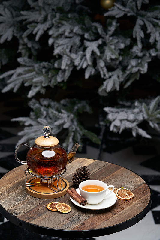 圣诞茶与圣诞树的背景。一杯茶和一个水壶
