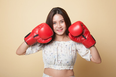 戴着红色拳击手套的年轻亚洲女子。