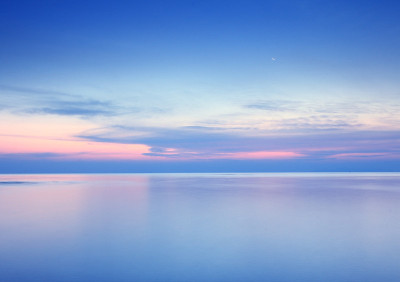 海滩日出与戏剧性的天空，大海和月亮的背景