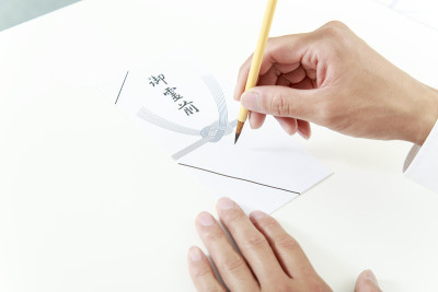 用毛笔把名字写在送去葬礼的钱袋上