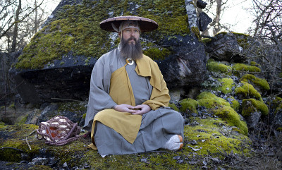 蓄着胡须的欧洲男人穿着传统的日本修道服装进行冥想