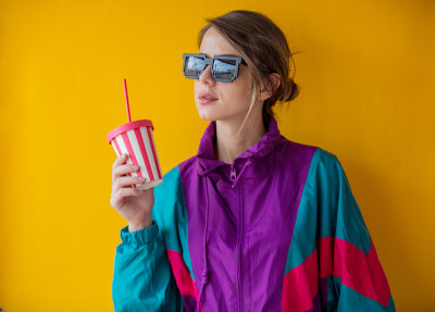 年轻女子穿着90年代风格的衣服，带着杯子