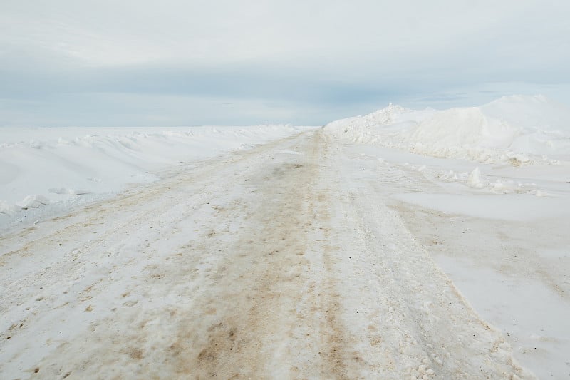 清除道路或人行道上的积雪并撒上盐、沙以保证交通安全。雪沿着道路堆积