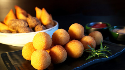 巴西小吃bolinha de queijo，油炸丸子里塞满了奶酪，深色背景