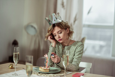 生日妇女用打火机点燃蛋糕上的蜡烛