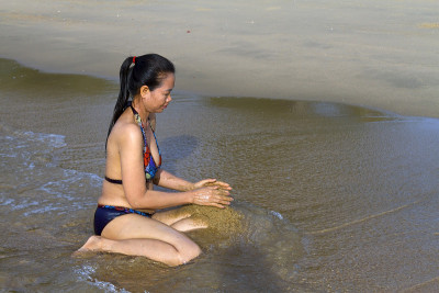 女士用泳衣玩沙子