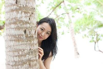 一个日本女人在沙滩上的棕榈树下