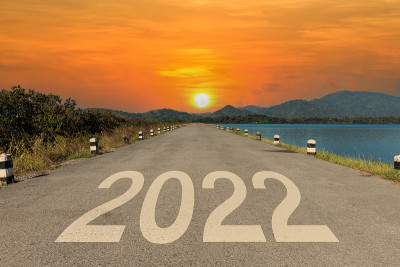 在空旷的柏油路和美丽的日落天空中间的高速公路上写着2022年。新2022年。概念规划与挑战，经营策略