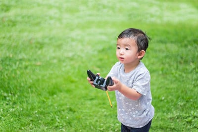 一个亚洲小孩拿着无线电遥控器。浅景深