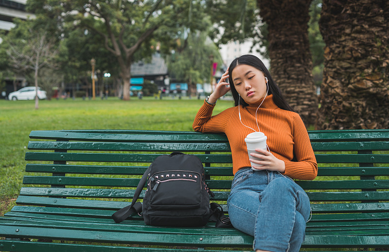 听音乐的亚洲女人。