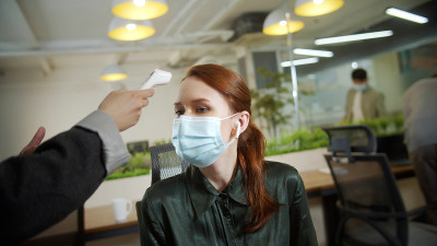 一位女商人的同事正在测量体温