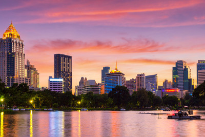泰国曼谷，市中心公园的自然湖，有商业建筑和日落天空的背景