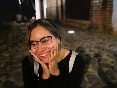 美丽的年轻拉丁女孩微笑与手在她的脸和千禧一代的风格