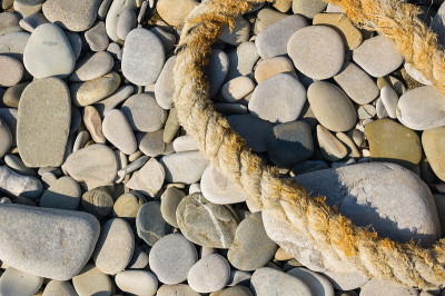 old marine rope on the pebble beach