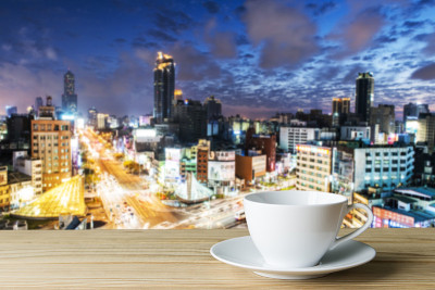 木地板，一杯热咖啡，城市夜晚模糊抽象的背景