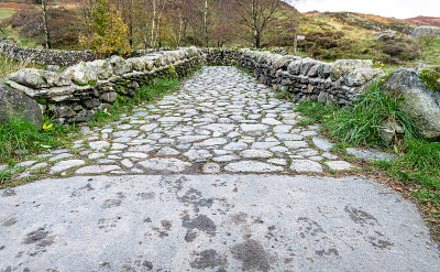 在英国坎布里亚湖区的Watendlath Tarn，一座石桥横跨Watendlath Beck