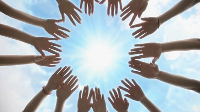 一群年轻人用手围成一个圈。多元化人才携手合作伙伴关系
