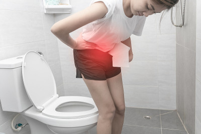 女人在家里上厕所时正遭受腹痛。月经