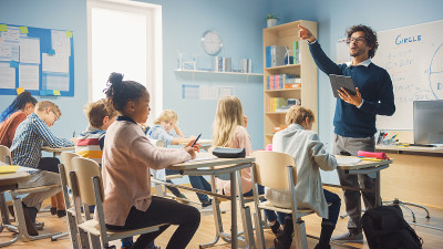充满热情的老师在小学给形形色色的孩子们上课。一群聪明的多民族孩子学习新东西。侧面拍摄