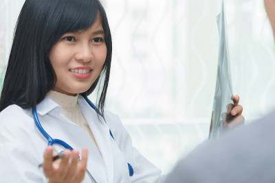女医生用x光片检查肺部。