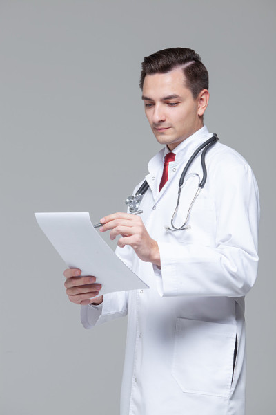 年轻医生的肖像在白色制服与听诊器夹