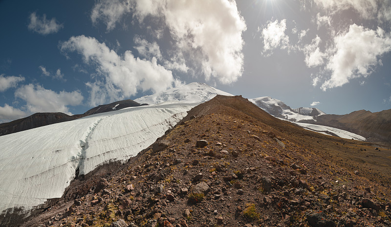 火山岩石的全景背景和冰川瀑布从厄尔布鲁斯山的西北侧