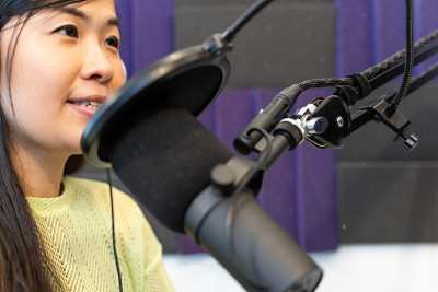 亚洲女孩电台DJ在广播演播室读新闻。亚洲女孩电台DJ在广播演播室读新闻。