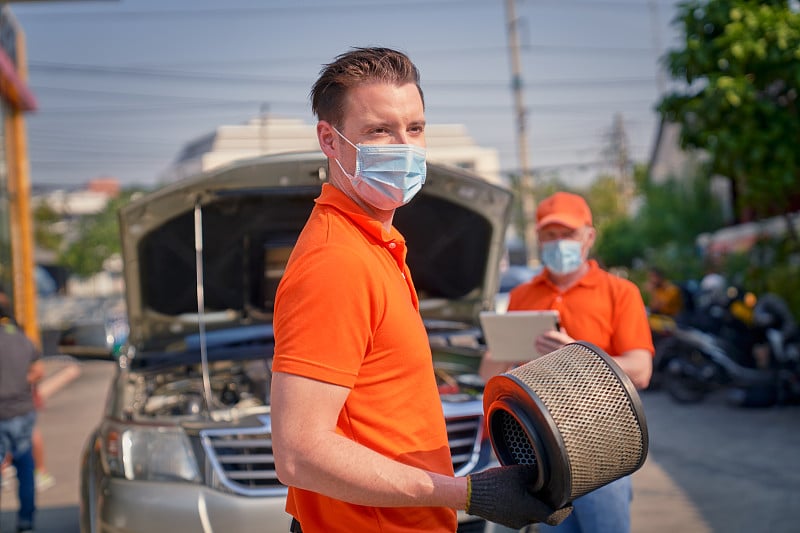 白人男性机械师拿着汽车空气滤清器维修