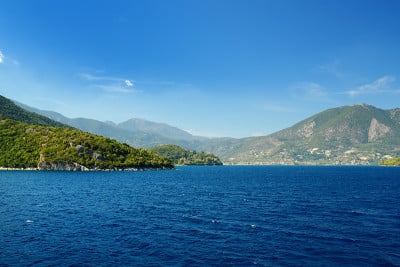 Nidri港口的风景，船只和游艇经过。夏日阳光明媚的莱夫卡达岛海岸。