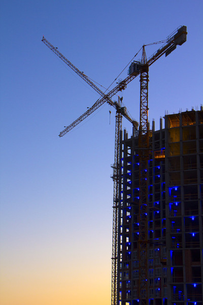 塔吊映衬着蓝天，建筑过程中形成了多层建筑