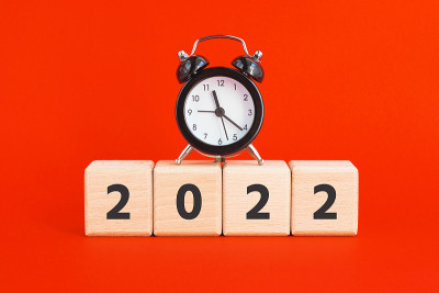 木制立方体2022和红色背景的迷你闹钟。新年，时间观念。街区。