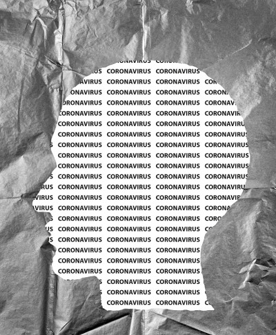 皱巴巴的纸人头上印着冠状病毒文字。COVID-19危机的概念。