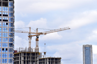 一个大型建筑工地的视图。塔吊正在工作。起重机和建筑工在建筑模板上