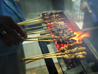 巴厘岛库塔，一名厨师在街上准备肉串