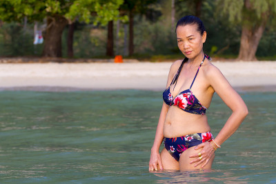 身材性感的女人在沙滩上展示美丽的比基尼