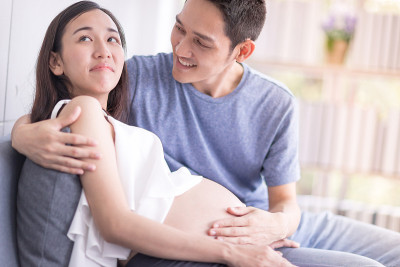 夫妻关系的概念。丈夫试图与妻子和解，亚洲妇女怀孕了。