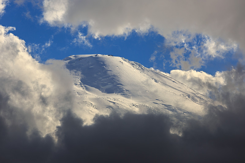 厄尔布鲁斯山的西峰，从云中可以看到雪坡。位于俄罗斯北高加索山脉。